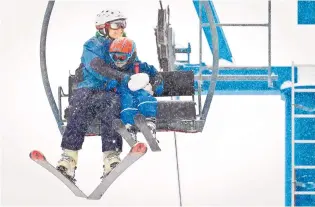  ?? MARLA BROSE/JOURNAL ?? Ali Hurt holds on tight to her 2-year-old son, Felix, as they ride a chairlift at the Sandia Peak Ski Area, which opened for the season Saturday. “I hear it’s really good and getting better by the second,” said area manager Ben Abruzzo, speaking about...