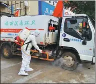  ?? LI JIANFEI / FOR CHINA DAILY ?? An epidemic control worker disinfects a sanitation truck at the entrance of a community that has been locked down in Ruili, Yunnan province, on Tuesday.