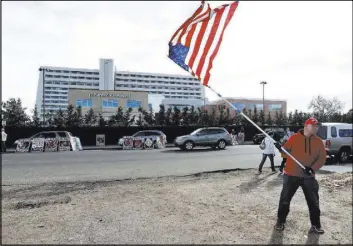  ?? BRENNAN LINSLEY/THE ASSOCIATED PRESS ?? Jeff McNamara wears a Trump campaign hat as he waves a U.S. flag during an antiaborti­on rally Saturday in front of Planned Parenthood of the Rocky Mountains in Denver.