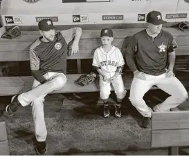  ?? Karen Warren / Houston Chronicle ?? Cameron Gooch, 9, sits in the dugout with Astros pitchers Collin McHugh, left, and Will Harris before the start of the game with the D-Backs at Minute Maid Park on Thursday. Cameron was participat­ing in the Make-A-Wish program.