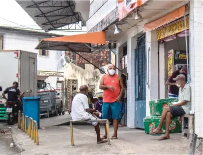  ?? FOTOS DE NARA GENTIL ?? Homens conversam em Pau da LIma, um dos bairros com piores índices de isolamento social em Salvador