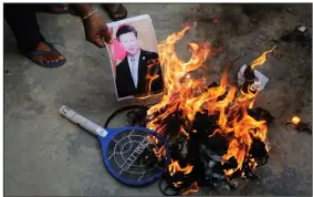  ?? (AP/Ajit Solanki) ?? A photograph of Chinese President Xi Jinping is set on fire Tuesday in Ahmedabad, India, during a protest after the latest confrontat­ion between Indian and Chinese troops along their disputed border in the Himalayas.