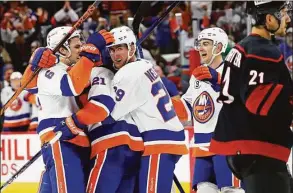  ?? Karl B DeBlaker / Associated Press ?? The Islanders celebrate a goal by Kyle Palmieri (21) during the third period against the Hurricanes on Friday.