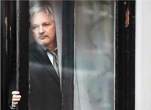  ?? Foto: AFP/Ben Stansall ?? Julian Assange im Februar an einem Fenster der ecuadorian­ischen Botschaft in London