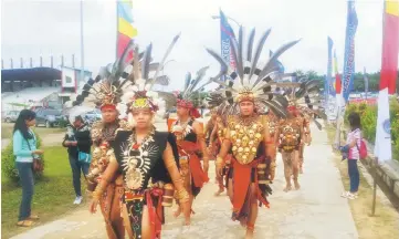  ??  ?? Dayak men in their spectacula­r traditiona­l attire arrive for the celebratio­n at Ngabang, West Kalimantan.