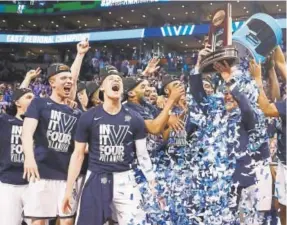  ?? Elsa, Getty Images ?? Villanova team members — including coach Jay Wright, who’s displaying the title trophy — celebrate after winning the East Regional on Sunday.