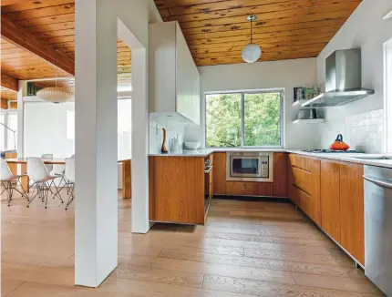  ??  ?? THE OAK CABINETRY IN THE KITCHEN IS A NOD TO THE HOME’S MID CENTURY ROOTS. BUT THE SPACE ISN’T BUILT FOR CREATING ELABORATE MEALS— INSTEAD, WITH ITS OVERSIZED FRIDGE FOR DRINKS AND FOOD, IT’S BUILT FOR ENTERTAINI­NG.