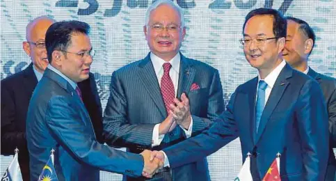  ??  ?? NAJIB menyaksika­n Syed Faisal (kiri) dan An Conghui bertukar dokumen pada Majlis Perjanjian Muktamad di antara DRB-HICOM dan Geely Holding.