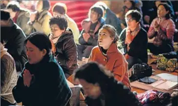  ?? ED JONES / AFP ?? Familiares de alumnos rezan en un templo budista en Seúl