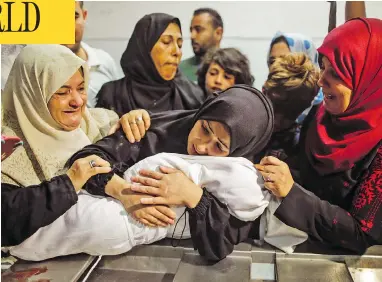  ?? MAHMUD HAMS / AFP / GETTY IMAGES ?? The mother of Leila al-Ghandour, an eight-month-old Palestinia­n baby who died during clashes in East Gaza on Monday, cradles her body at the morgue of al-Shifa hospital in Gaza City.