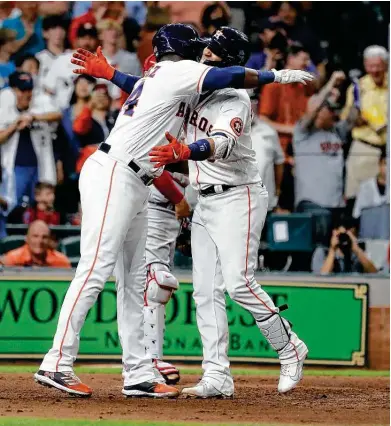  ?? Photos by Karen Warren / Staff photograph­er ?? Yuli Gurriel, right, is greeted by Yordan Alvarez after hitting a three-run homer to give the Astros some breathing room in a tense game. The homer capped a four-run eighth inning that included Michael Brantley’s tiebreakin­g single.