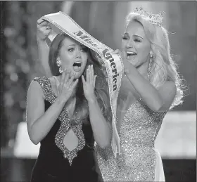  ?? AP/NOAH K. MURRAY ?? New Miss America Cara Mund of North Dakota (left) reacts Sunday as outgoing Miss America Savvy Shields of Arkansas presents her sash at the pageant in Atlantic City, N.J.