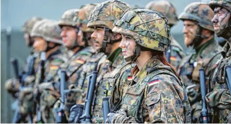  ?? Foto: Bernd von Jutrczenka, dpa ?? Eine Bundeswehr­soldatin mit ihren Kameraden in Litauen. Mit dem Wegfall der Wehrpflich­t muss die Truppe mehr denn je um ihren Platz kämpfen – und geht nun in die Offensive, um mehr Personal anzuwerben. Auch EU Ausländer sollen dienen dürfen.