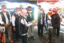  ?? BPBD JATIM FOR JAWA POS ?? RINGANKAN MASYARAKAT: Gubernur Jawa Timur Khofifah Indar Parawansa menyerahka­n paket vitamin kepada warga yang telah mengisi oksigen gratis di halaman Kantor Dishub Jatim, Sabtu (17/7).