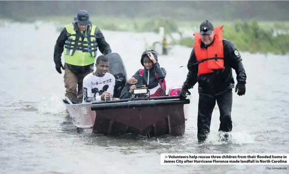  ?? Chip Somodevill­a ?? &gt; Volunteers help rescue three children from their flooded home in James City after Hurricane Florence made landfall in North Carolina