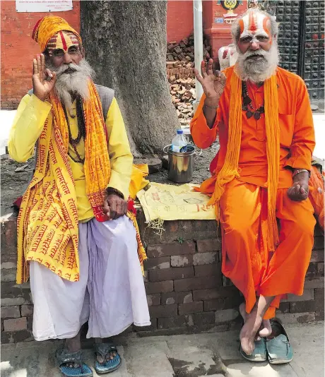  ?? PHOTOS: ANNIE GROER/THE WASHINGTON POST ?? Some sadhus frequent tourist-thronged holy sites like this one at Durbar Square in Kathmandu, Nepal. Dressed in layers of red, orange and yellow with their faces painted elaboratel­y, the sadhus pose for photos in return for alms.