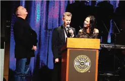  ??  ?? From left, artist Garth Brooks, artist Randy Travis and Mary Travis sing ‘Amazing Grace’ at the Country Music Hall of Fame Medallion Ceremony.