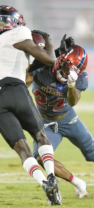  ?? MICHAELLAU­GHLIN/SOUTHFLORI­DASUNSENTI­NEL ?? WesternKen­tucky receiverCr­aig Burt Jr. is tackled by FloridaAtl­antic’s Zyon Gilbert on Saturday during the first half.