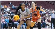  ?? (Arkansas Democrat-Gazette/Justin Cunningham) ?? UALR guard Tia Harvey (left) drives to the basket Thursday in front of Tennessee-Martin guard Paige Pipken at Simmons Bank Arena in North Little Rock. Harvey hit the game-winning three-pointer as time expired to give the Trojans a 45-44 victory. More photos at arkansason­line.com/1230womenu­alr/.