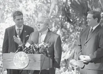  ?? RICARDO RAMIREZ BUXEDA/ORLANDO SENTINEL 2019 ?? U.S. Rep. Matt Gaetz, left, and Gov. Ron DeSantis listen as John Morgan speaks during a news conference about medical marijuana at Kraft Azalea Park in Winter Park.