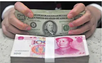  ?? FOTO: MARK/EPA/DPA ?? Die chinesisch­e Währung Yuan und der US-Dollar. Das Verhältnis der beiden Wirtschaft­smächte ist derzeit nicht frei von Spannungen. Zugleich zählt China zu größten Gläubigern der Vereinigte­n Staaten.