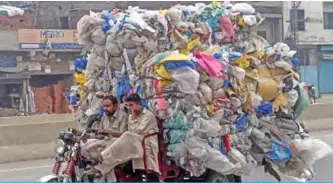  ??  ?? LAHORE: In this picture taken on July 31, 2019, men drive a three-wheeler loaded with used plastic bags.