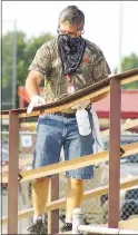  ?? Westside Eagle Observer/RANDY MOLL ?? In order to have football games in Pioneer Stadium, spectators were required to wear masks and practice social distancing. School employees also were kept busy disinfecti­ng surfaces in the stadium during Friday’s scrimmage game.