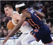  ?? MARY ALTAFFER — THE ASSOCIATED PRESS ?? Nuggets center Nikola Jokic, left, drives against Knicks forward Precious Achiuwa, right, in the first half on Thursday at Madison Square Garden in New York.