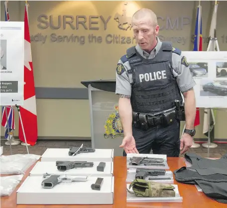  ?? JASON PAYNE/PNG ?? Surrey RCMP Cpl. Scotty Schumann displays the drugs and guns police recovered during the execution of multiple search warrants following a long-term joint investigat­ion into the traffickin­g of drugs that has resulted in more than 48 charges being laid...