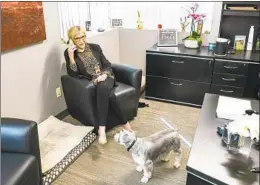  ?? EDUARDO CONTRERAS U-T PHOTOS ?? Jeanne Mcalister takes a call at her office in El Cajon recently. She usually arrives at work with her dogs, Joey and Oliver.