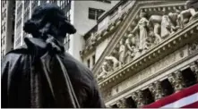  ?? BEBETO MATTHEWS — THE ASSOCIATED PRESS FILE ?? In this Wednesday file photo, Federal Hall’s George Washington statue stands near the flag-covered pillars of the New York Stock Exchange.