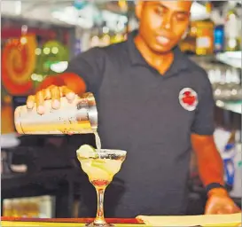  ?? Picture: JOVESA NAISUA ?? A bartender at the Grill Restaurant and Bar mixes a cocktail on the opening night.