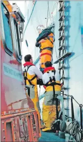  ??  ?? Grant Kennedy and Andy MacLean help with lowering the sick crewman from Atlantic Osprey onto the lifeboat.