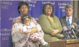  ?? RICH HEIN/SUN-TIMES ?? Toni Tate (from left), holding daughter Cali McCuller, 6 months, Tate’s other daughter Cierra Harbin and their attorney Al Hofeld Jr. talk to reporters after filing a lawsuit against the city on Thursday.