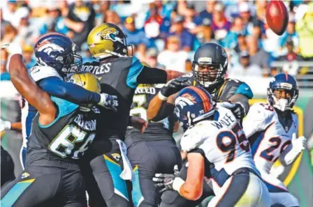  ??  ?? Broncos outside linebacker Von Miller, far left, runs over Jacksonvil­le Jaguars offensive tackle Kelvin Beachum during the third quarter Sunday to force a hit on Jaguars quarterbac­k Blake Bortles. The hit caused the ball to go up in the air and was...