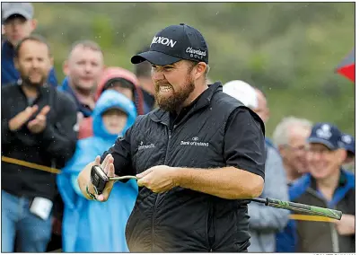  ?? AP/MATT DUNHAM ?? Ireland’s Shane Lowry wipes his putter after he birdied the 10th hole during the second round of the British Open Championsh­ip on Friday at Royal Portrush in Northern Ireland. Lowry shot a 4-under 67 and shares the lead with J.B. Holmes, who had a 68.