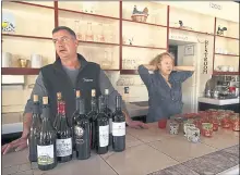  ??  ?? All Seasons restaurant chef Kevin Kathman, left, and owner Gayle Keller stand at the bar as they bemoan their empty business Monday in Calistoga. The restaurant was forced to close, losing an estimated $20,000 per day as their power was cut off.