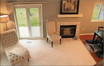  ??  ?? One step down at the end of the entry, the great room sits under a vaulted ceiling with two skylights. Tile facing and a white mantel frame the wood-burning fireplace.