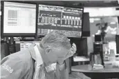  ?? MARK LENNIHAN AP ?? A trader reacts after New York Stock Exchange trading was halted March 18, 2020.