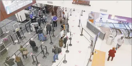  ??  ?? Passengers socially distance as they wait to go through the security screening area at the Albany airport.