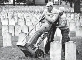  ?? ERIC ALBRECHT/AP ?? Workers move the vandalized statue of a Civil War soldier at Camp Chase Confederat­e Cemetery in Columbus, Ohio. The VA has spent nearly $3 million safeguardi­ng cemeteries.