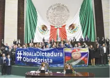  ??  ?? El PAN subió a tribuna con una manta con la leyenda: “#no a la dictadura obradorist­a”, que incluía una foto de Hugo Chávez, con el rostro de AMLO.