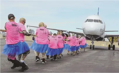  ?? STAFF PHOTOS BY NICOLAUS CZARNECKI ?? RAISING $$, SPIRITS: Team Wicked Jeeps pulls a commercial jet as hundreds take part in the JetBlue Pulling For Hope of Boston fundraiser for the American Cancer Society yesterday. Team Angels Wings, below, and Team Vera Care, bottom right, test their strength for the charity.