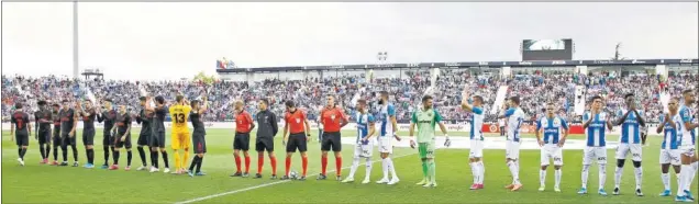  ??  ?? SALUDOS. Los jugadores de ambos equipos saludan al público de Butarque en el inicio del partido entre Leganés y Atlético.