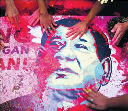  ?? J Gerard Seguia / Pacific Press / LightRocke­t via Getty Images ?? Supporters touch a poster of Rodrigo Duterte during a rally in central Manila in support of the controvers­ial president whose policies include the extrajudic­ial killing of drug dealers and users.