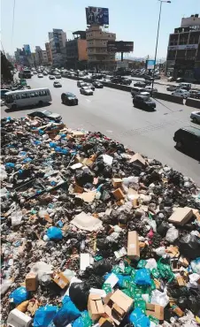  ?? Rex Features ?? People drive past a mountain of garbage in Beirut. Lebanon has faced a chronic waste problem since 2015.