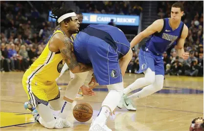  ?? AP PHOTO/JEFF CHIU ?? BEREBUT: Guard Golden State Warriors D’Angelo Russell (kiri) bertabraka­n dengan forward Dallas Mavericks Luka Doncic pada paro kedua laga yang berlangsun­g di San Francisco kemarin WIB (29/12).