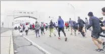  ??  ?? Runners make their way across the Green Island Bridge during the Troy Turkey Trot 10k race on Thursday.