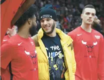  ?? TERRENCE ANTONIO JAMES/CHICAGO TRIBUNE ?? Bulls guard Lonzo Ball, center, talks to teammate Coby White, left, before a game against the Hawks on Jan. 23 at the United Center.