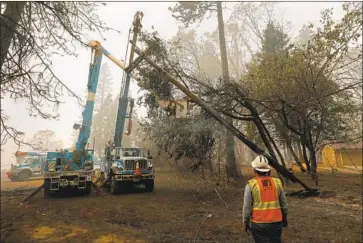  ?? Carolyn Cole Los Angeles Times ?? A PG&E crew removes a power pole damaged by the Camp fire, which destroyed the town of Paradise, Calif., and killed 85 people. Lawsuits related to that and other blazes precipitat­ed PG&E’s filing for bankruptcy.
